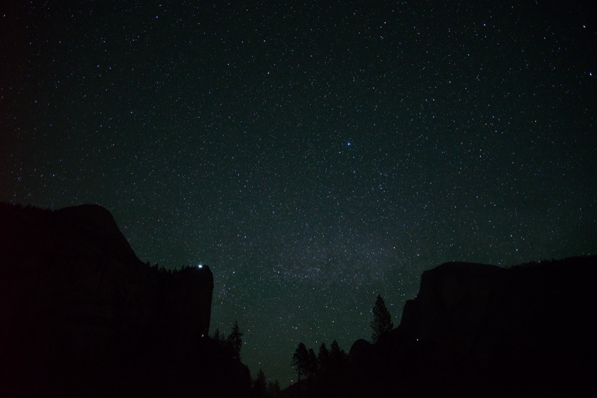 Yosemite valley silhouetted against a star-filled night sky